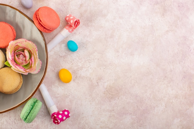 A top view colorful french macarons yummy on the pink desk sugar cake biscuit sweet