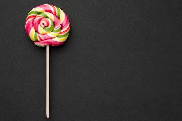 Top view colorful lollipop on black table