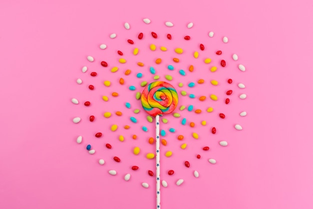 Free Photo a top view colorful lollipop with colored candies on pink, candy color sugar rainbow