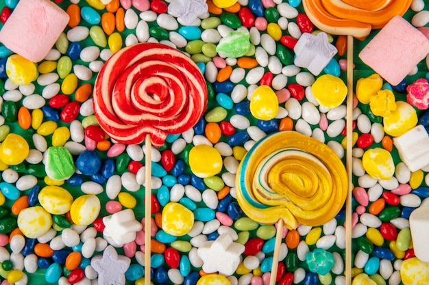 Free photo top view of  colorful lollipops on candies in multi-colored glaze background