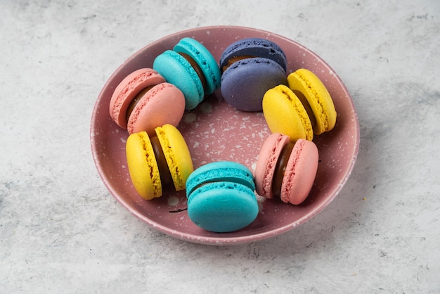 Top view of colorful pastel macarons on white surface.