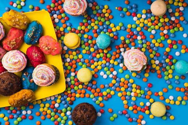 Top view colorful pastries surrounded by bonbon