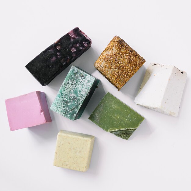 Top view of colorful soap bars on white backdrop