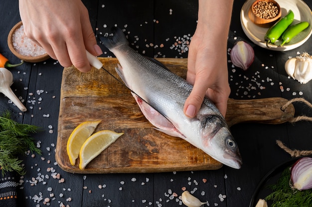 Free photo top view cook cleaning fish in kitchen