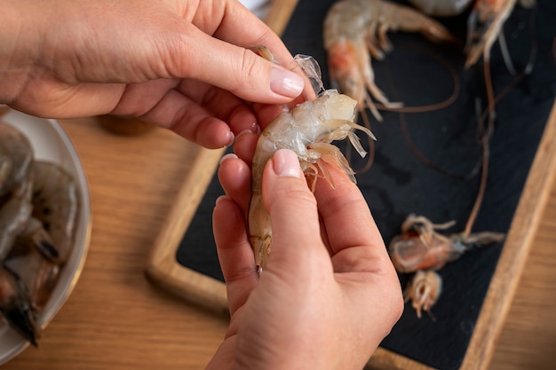 Free photo top view cook cleaning shrimp in kitchen