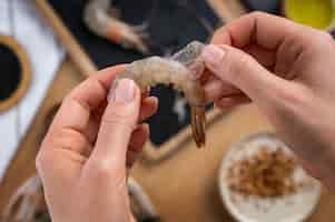 Free photo top view cook cleaning shrimp in kitchen