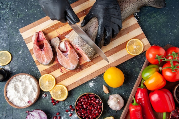 Free photo top view cook cutting raw fish on chopping board flour bowl on table