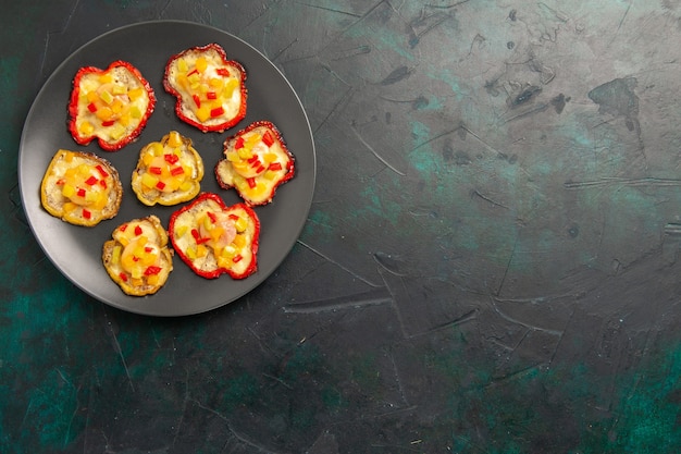 Free photo top view cooked bell-peppers for lunch inside plate on dark surface