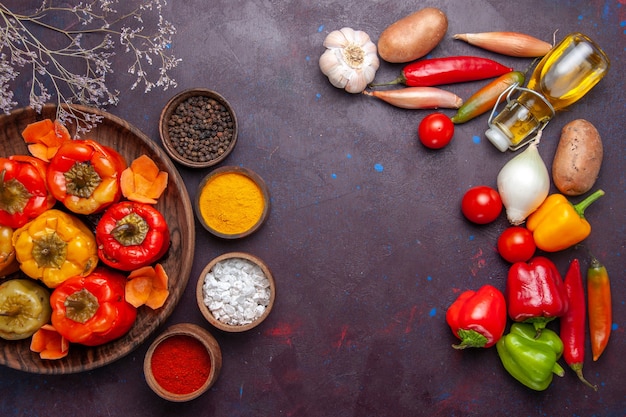 Top view cooked bell-peppers with fresh vegetables on the dark-grey surface meal vegetable meat dolma food