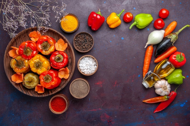 Top view cooked bell-peppers with fresh vegetables and seasonings on a grey surface meal dolma food vegetables beef meat