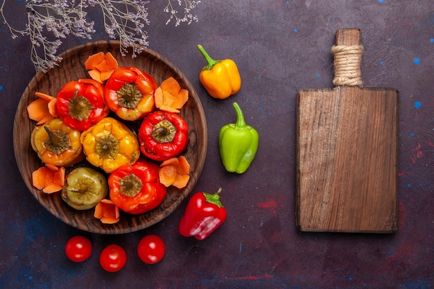 Free photo top view cooked bell-peppers with ground meat on dark-grey surface meat vegetables beef meal