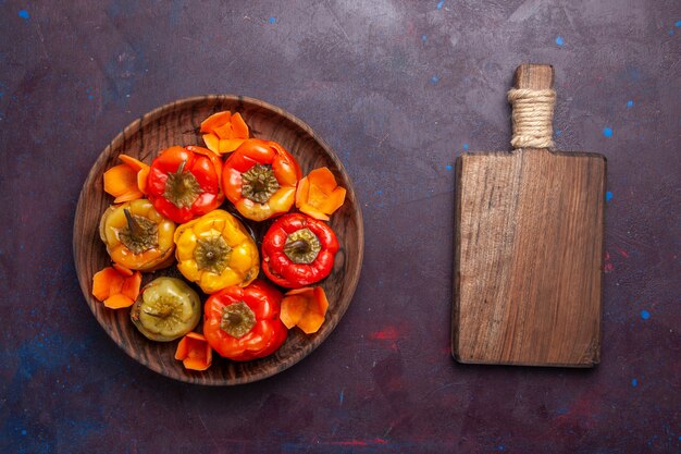 Free photo top view cooked bell-peppers with ground meat inside on grey surface meal food meat vegetable cooking