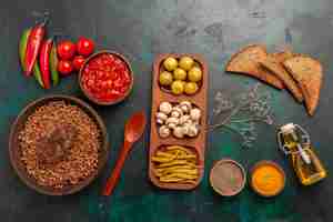 Free photo top view cooked buckwheat with cutlet and tomato sauce on green desk