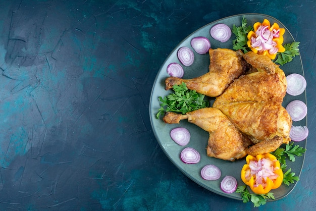 Top view cooked chicken with greens inside plate on the dark-blue desk chicken meat dinner meat