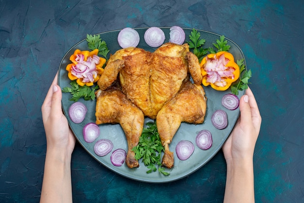 Top view cooked chicken with greens inside plate on the dark-blue floor chicken meat food dinner meat