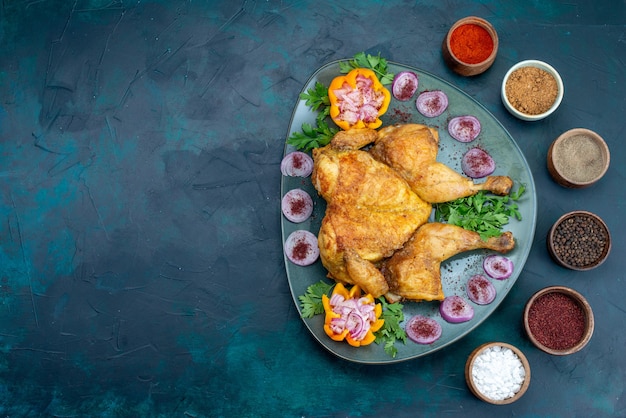 Top view cooked chiken with onions and greens inside plate on the dark blue desk chicken meat bake oven dinner