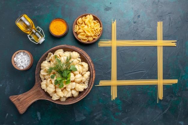 Free photo top view cooked dough pasta with greens and olive oil on dark surface