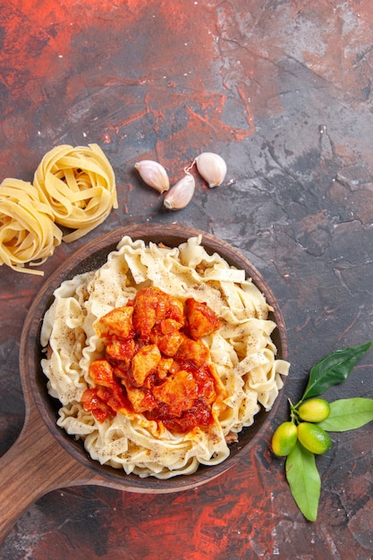 Top view cooked dough with chicken and sauce on a dark surface dark pasta dough dish