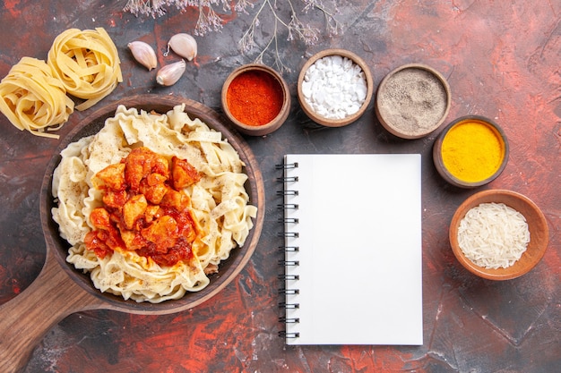 Free photo top view cooked dough with chicken and sauce on dark surface dough dark pasta dish