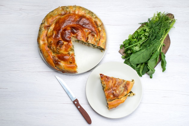 Top view cooked greens pastry sliced inside plates with fresh greens on the brown wooden desk food meal pastry green dinner