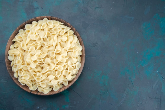 Top view cooked italian pasta inside brown plate on dark