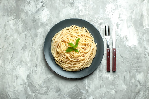 Top view cooked italian pasta with cutlery on a white background