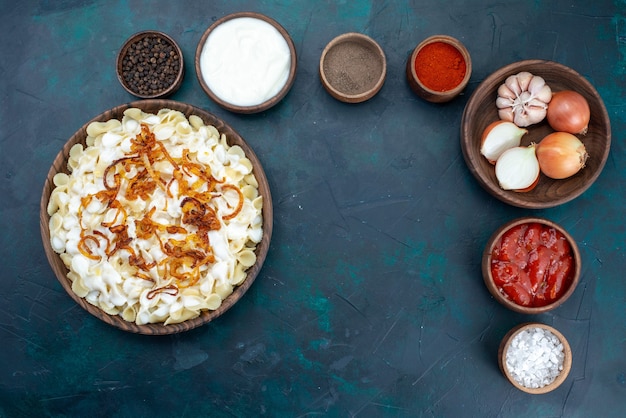 Free Photo top view cooked italian pasta with different seasonings on a blue desk