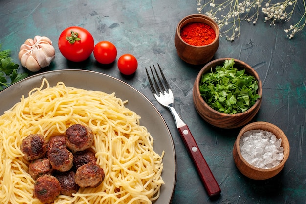 Free Photo top view cooked italian pasta with meatballs seasonings and greens on the dark blue surface