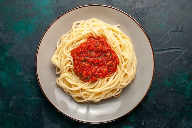 Free photo top view cooked italian pasta with minced meat and tomato sauce on dark-blue surface