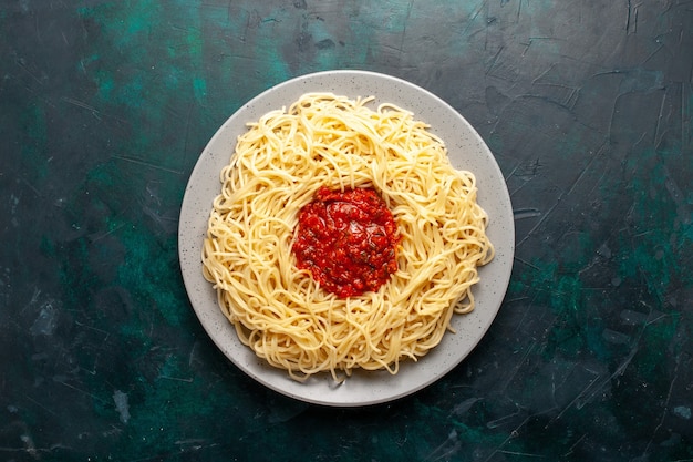 Free Photo top view cooked italian pasta with minced meat and tomato sauce on dark-blue surface