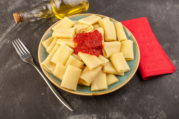 Free photo a top view cooked italian pasta with tomato sauce inside plate dish