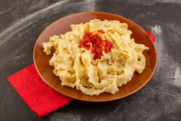 A top view cooked italian pasta with tomato sauce inside plate