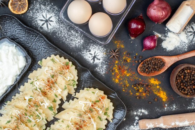 Top view cooked meat dumplings with different ingredients on dark background vegetable dish cooking meal dough dinner pepper