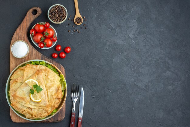 Top view cooked pita slices inside plate with lemon on dark surface