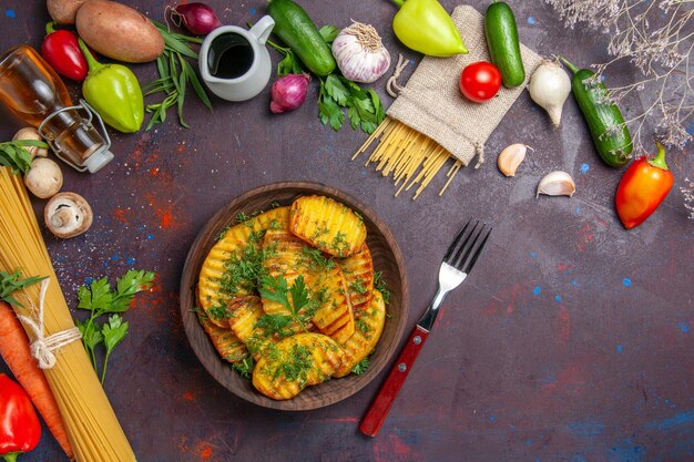 Top view cooked potatoes delicious dish with greens on a dark surface potato dinner meal food