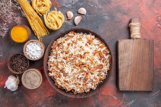 Top view cooked rice along with seasonings on dark desk food dish photo meal