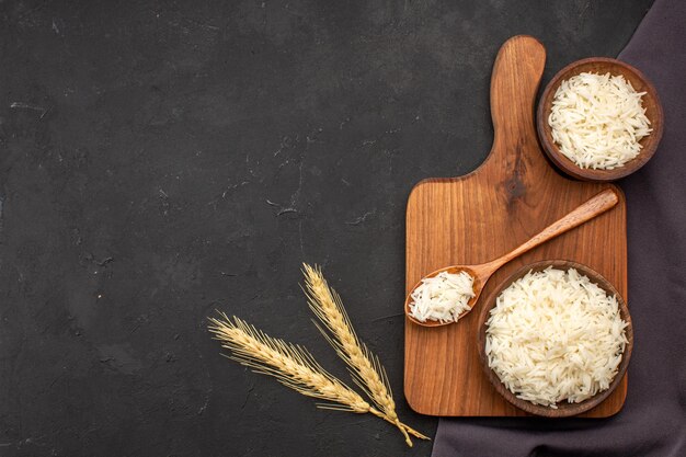 Top view cooked rice inside plates on dark space