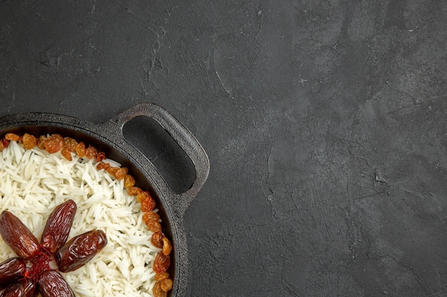 Free Photo top view cooked rice with raisins inside pan on dark grey surface meal food rice eastern dinner