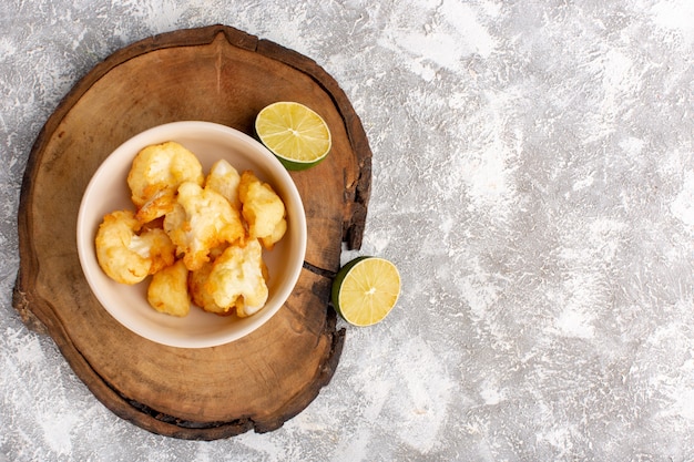 Free photo top view of cooked sliced cauliflower inside plate with lemon on grey-light surface