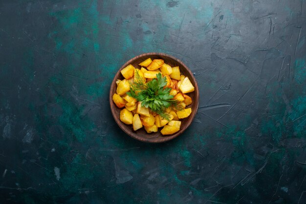 Free Photo top view cooked sliced potatoes with greens inside brown plate on dark blue surface