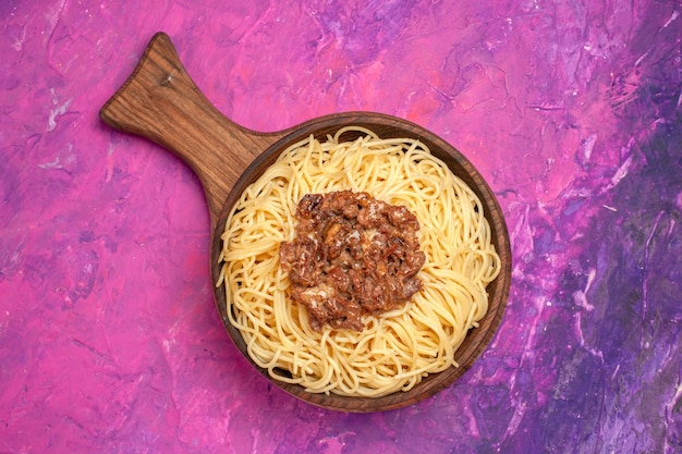 Top view cooked spaghetti with ground meat on a pink table dough dish pasta seasoning