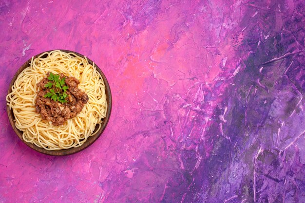 Top view cooked spaghetti with ground meat on the pink table dough meal pasta dish