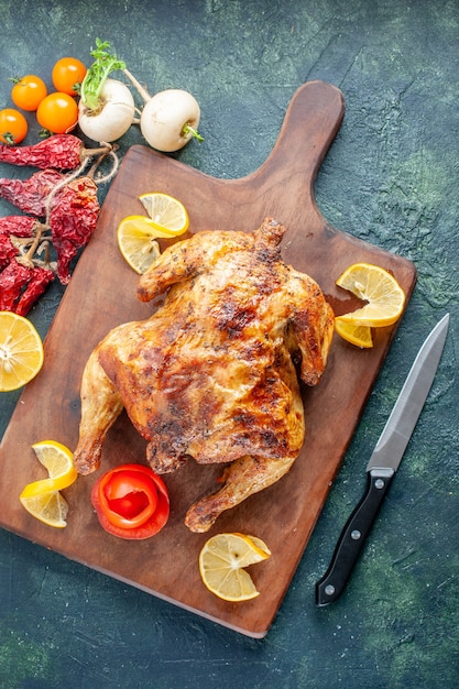 Top view cooked spiced chicken with lemon slices on dark surface