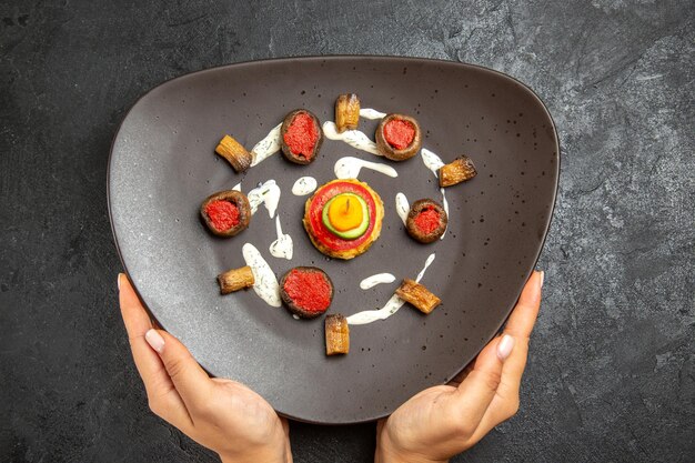 Top view of cooked squashes designed meal inside plate on a grey surface