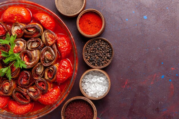 Top view cooked vegetable meal tomatoes and eggplants rolled and cooked with seasonings on the dark desk