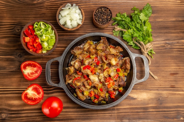 Free photo top view cooked vegetable meal with meat and fresh sliced bell-pepper on the wooden brown desk