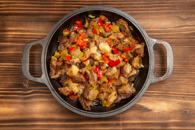 Free Photo top view cooked vegetable meal with meat and sliced bell peppers on the brown desk