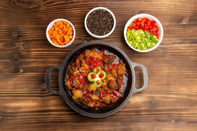 Free Photo top view cooked vegetable meal with seasonings and sliced bell-pepper on brown desk