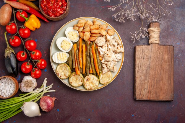 Top view cooked vegetables with egg meal and fresh vegetables on dark floor meal food lunch vegetable product