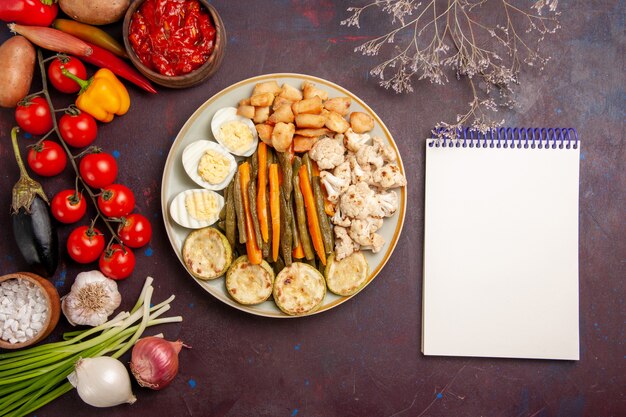 Top view cooked vegetables with egg meal and fresh vegetables on a dark space